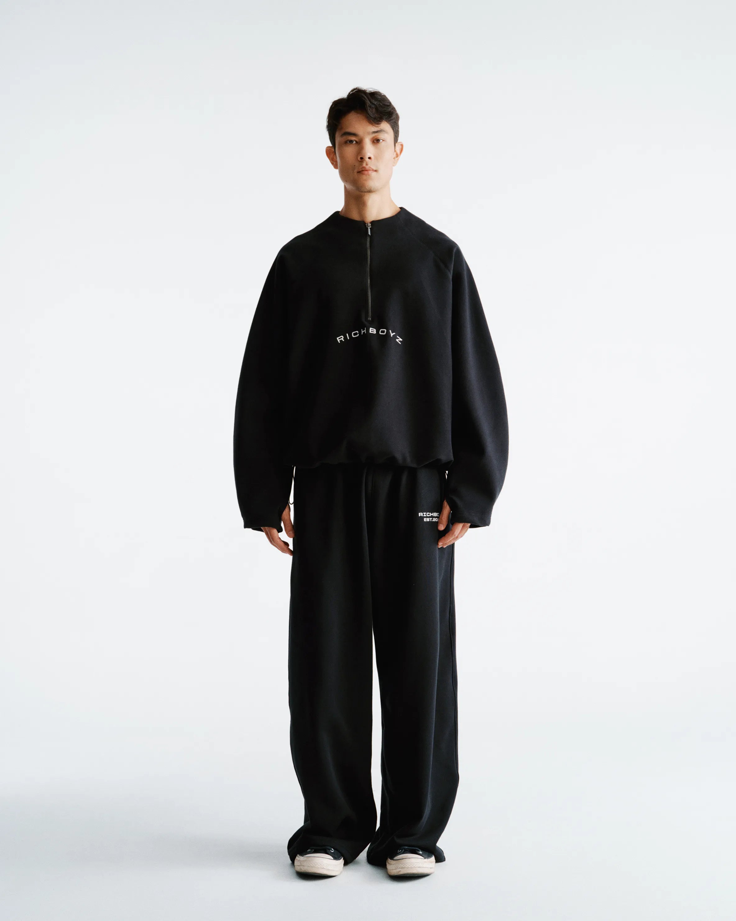 Person wearing a black outfit with text on a white background