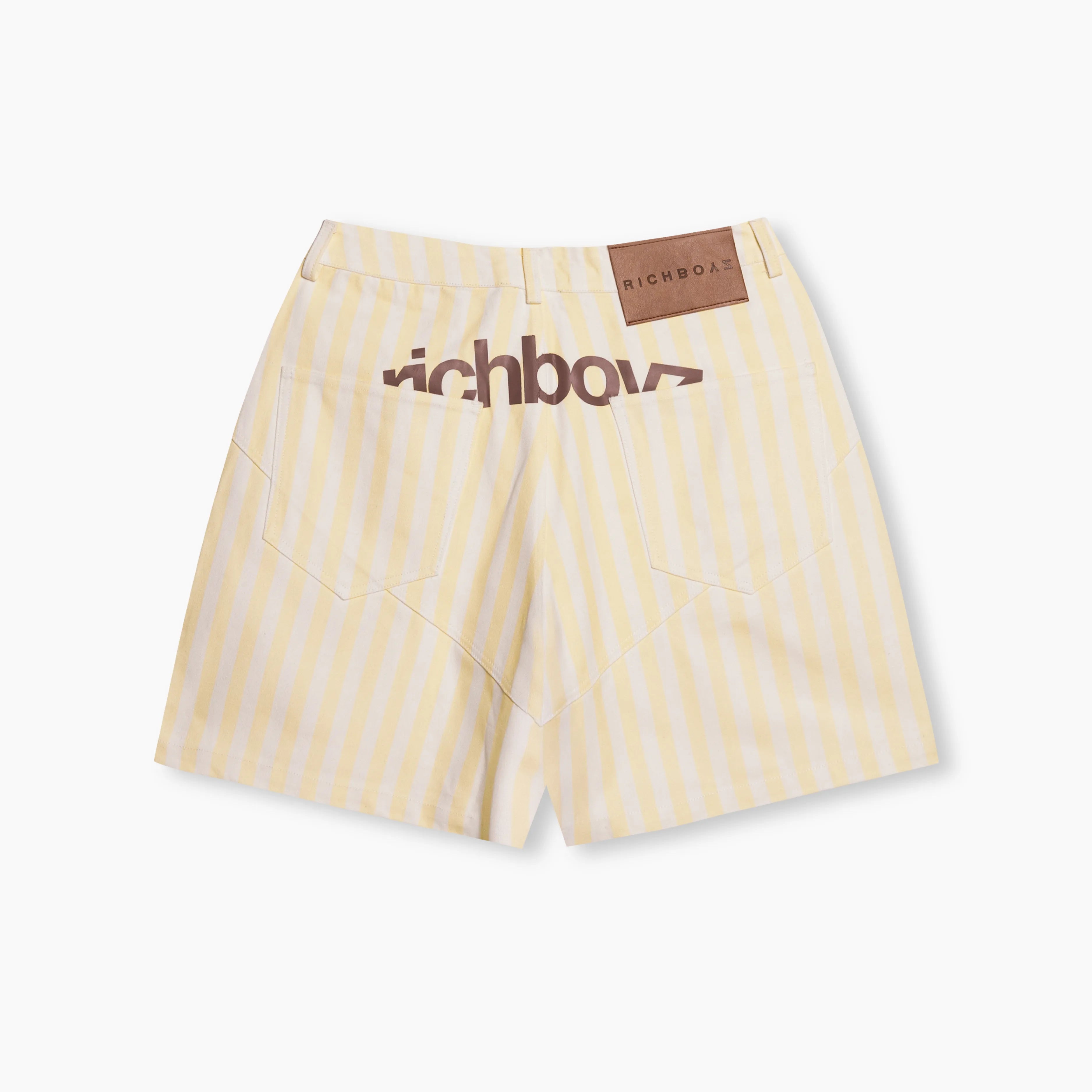 Yellow striped shorts with a brand label on a white background