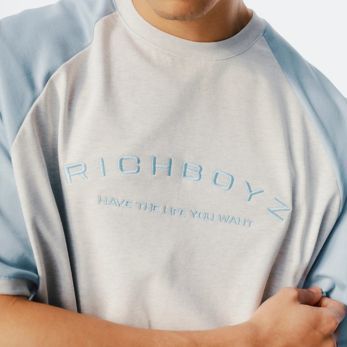 Close-up of Raglan Tee soft fabric texture and raglan sleeve seam detail in Heather Gray